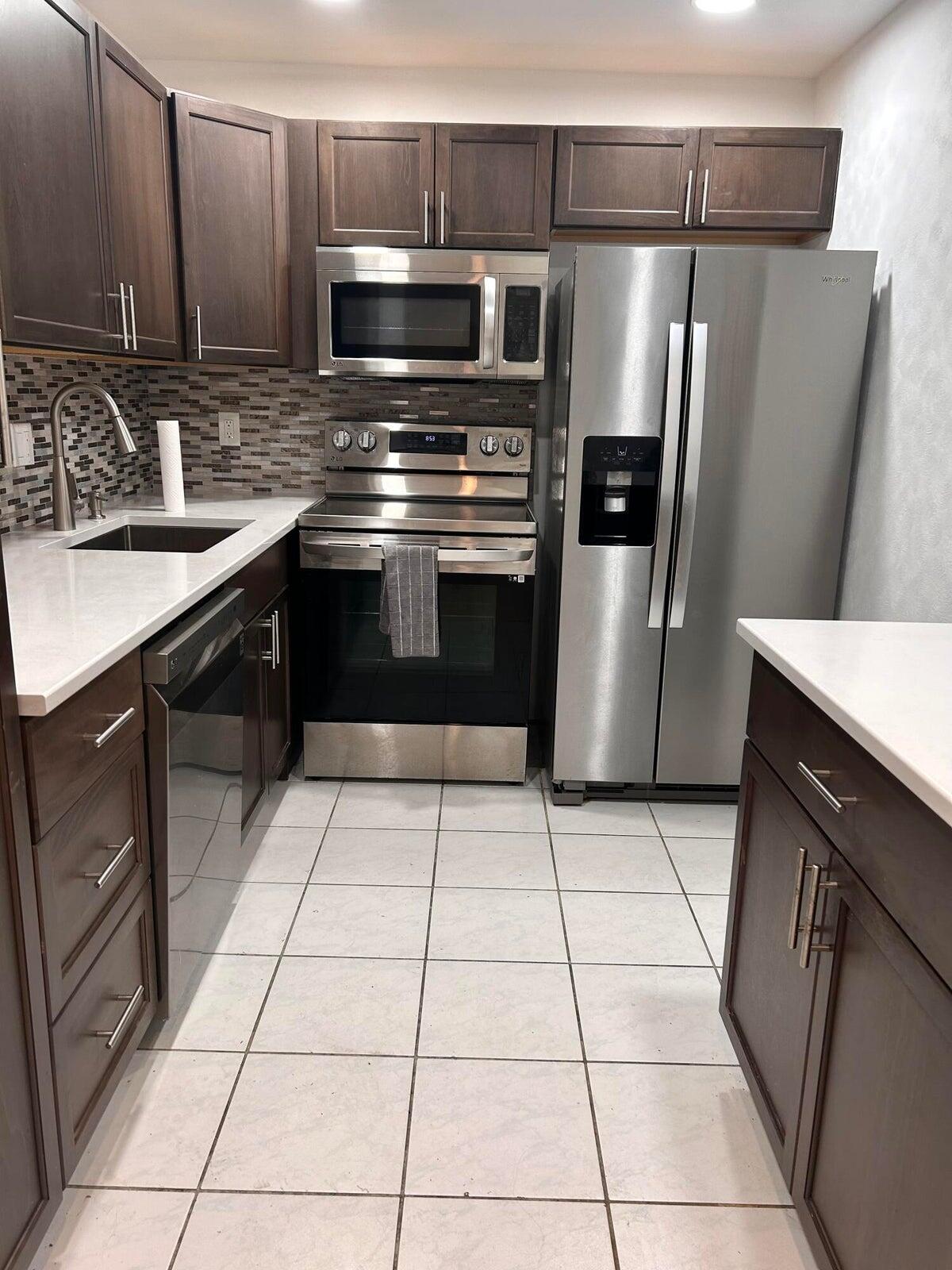 a kitchen with stainless steel appliances a sink and a microwave