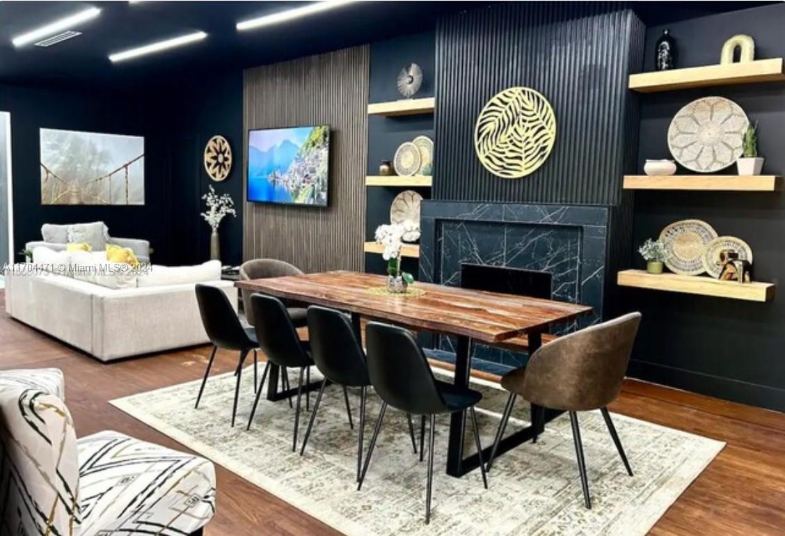 a view of a dining room with furniture a rug and wooden floor