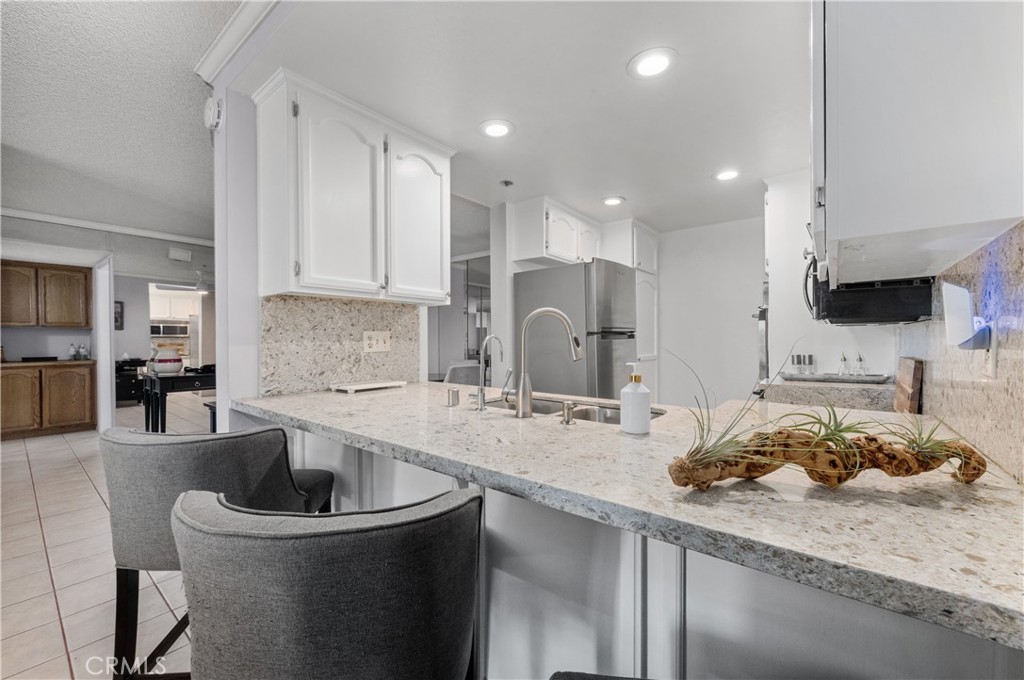 a kitchen with a sink a stove and chairs