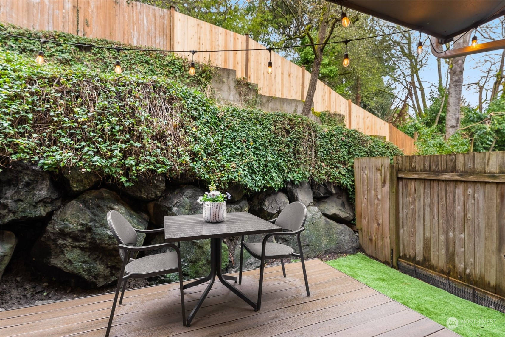 a backyard of a house with table and chairs plants