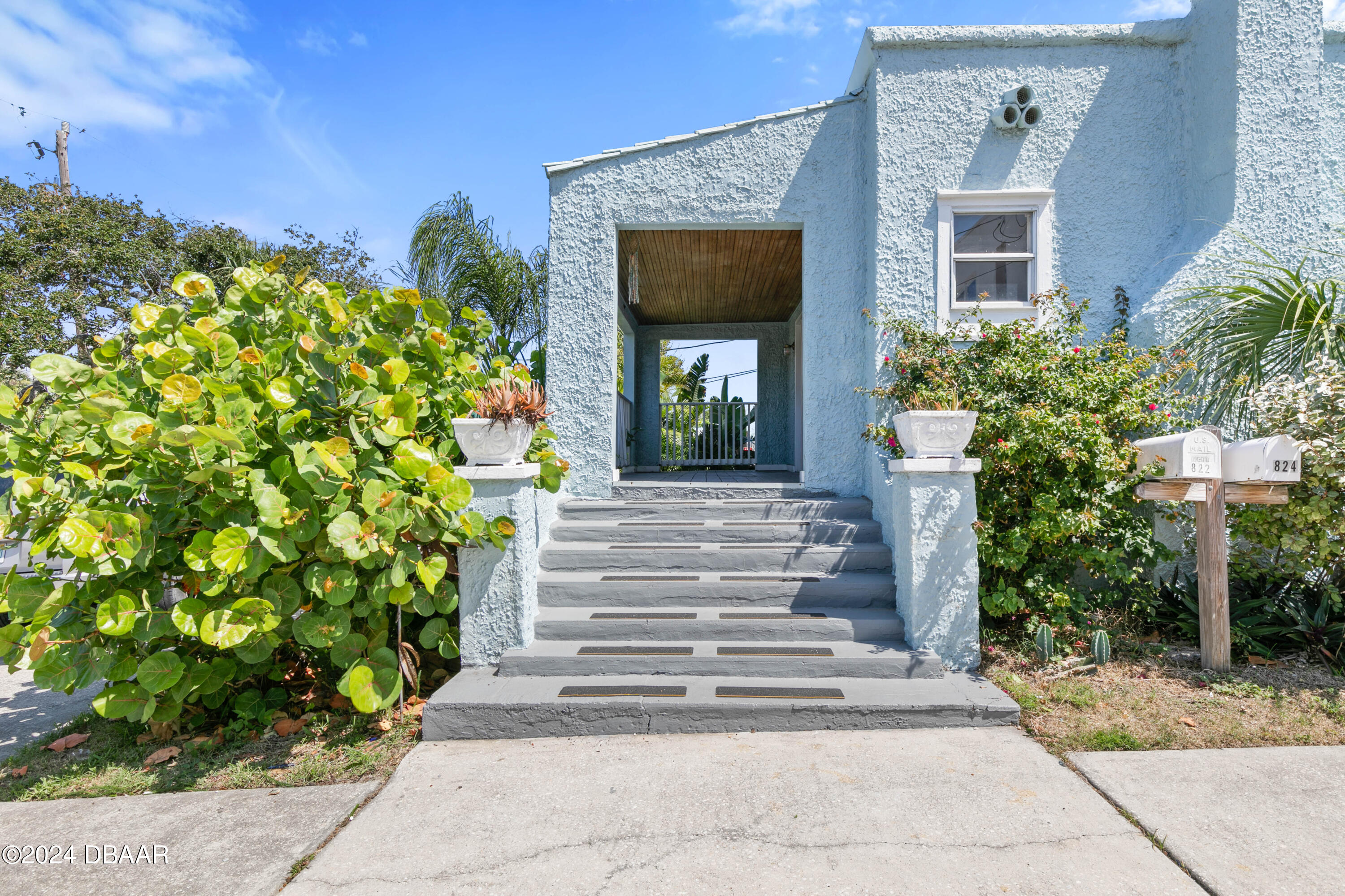 a front view of a house with potted plants