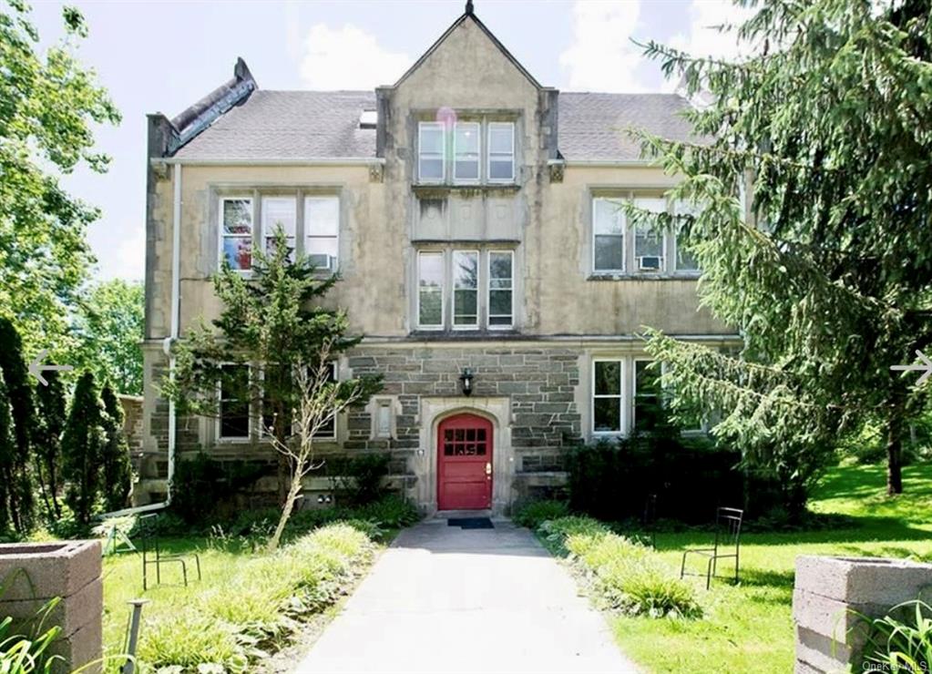 a front view of a house with a yard and a garden