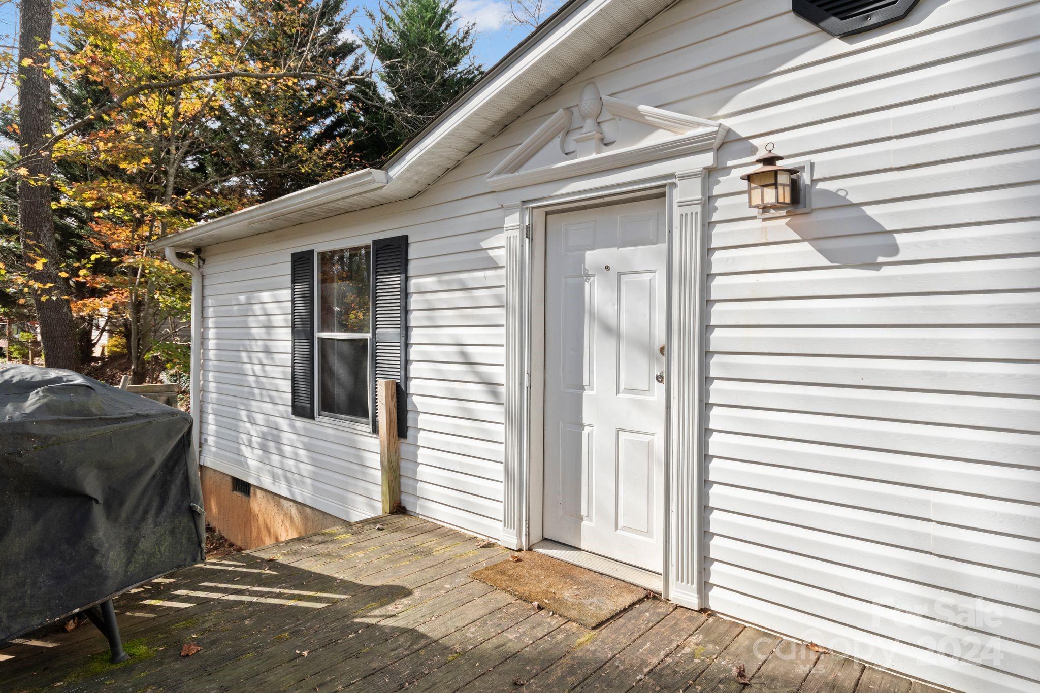 a view of a house with a door and wooden walls