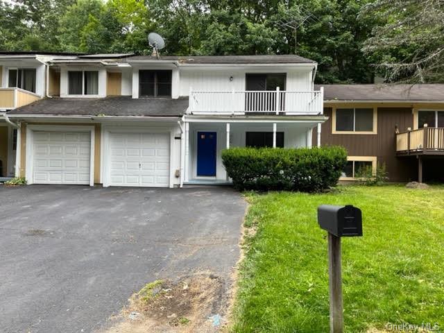 a front view of a house with a yard and trees