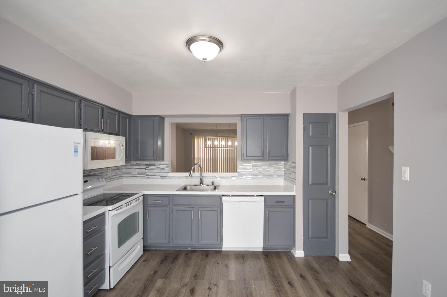 a kitchen with a sink a refrigerator a microwave and cabinets