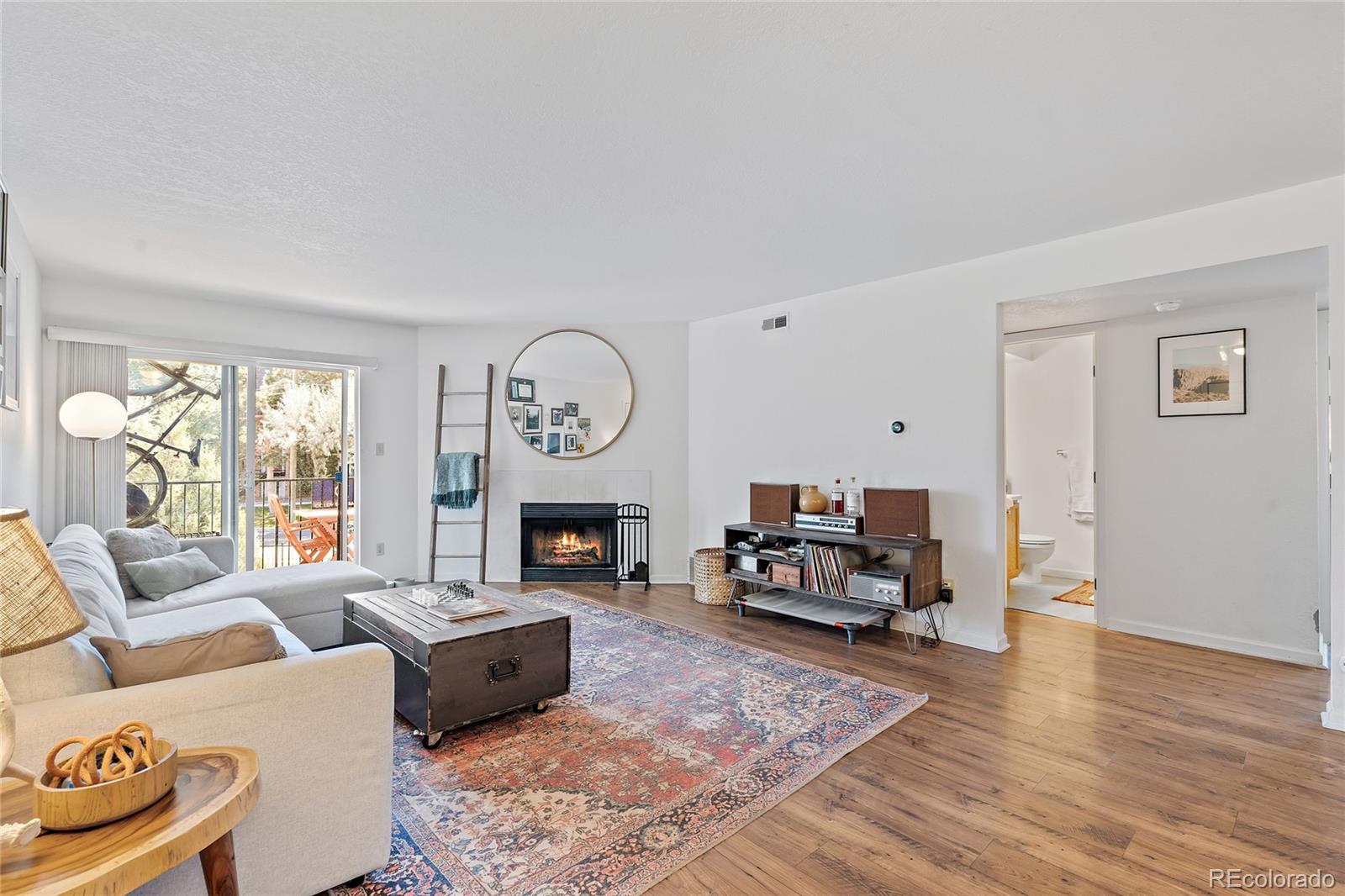 a living room with furniture a fireplace and a large window