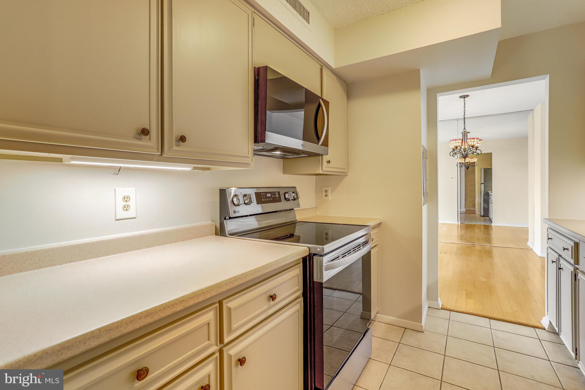 a kitchen with stainless steel appliances granite countertop a sink and a stove top oven with wooden floor