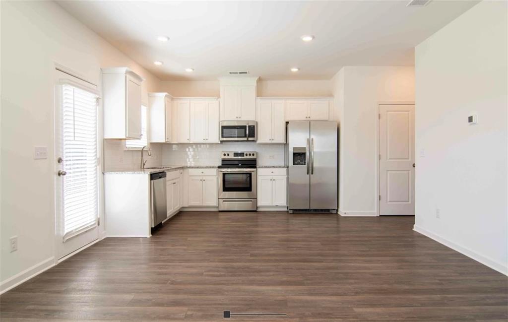 a kitchen with stainless steel appliances granite countertop a refrigerator and a stove top oven