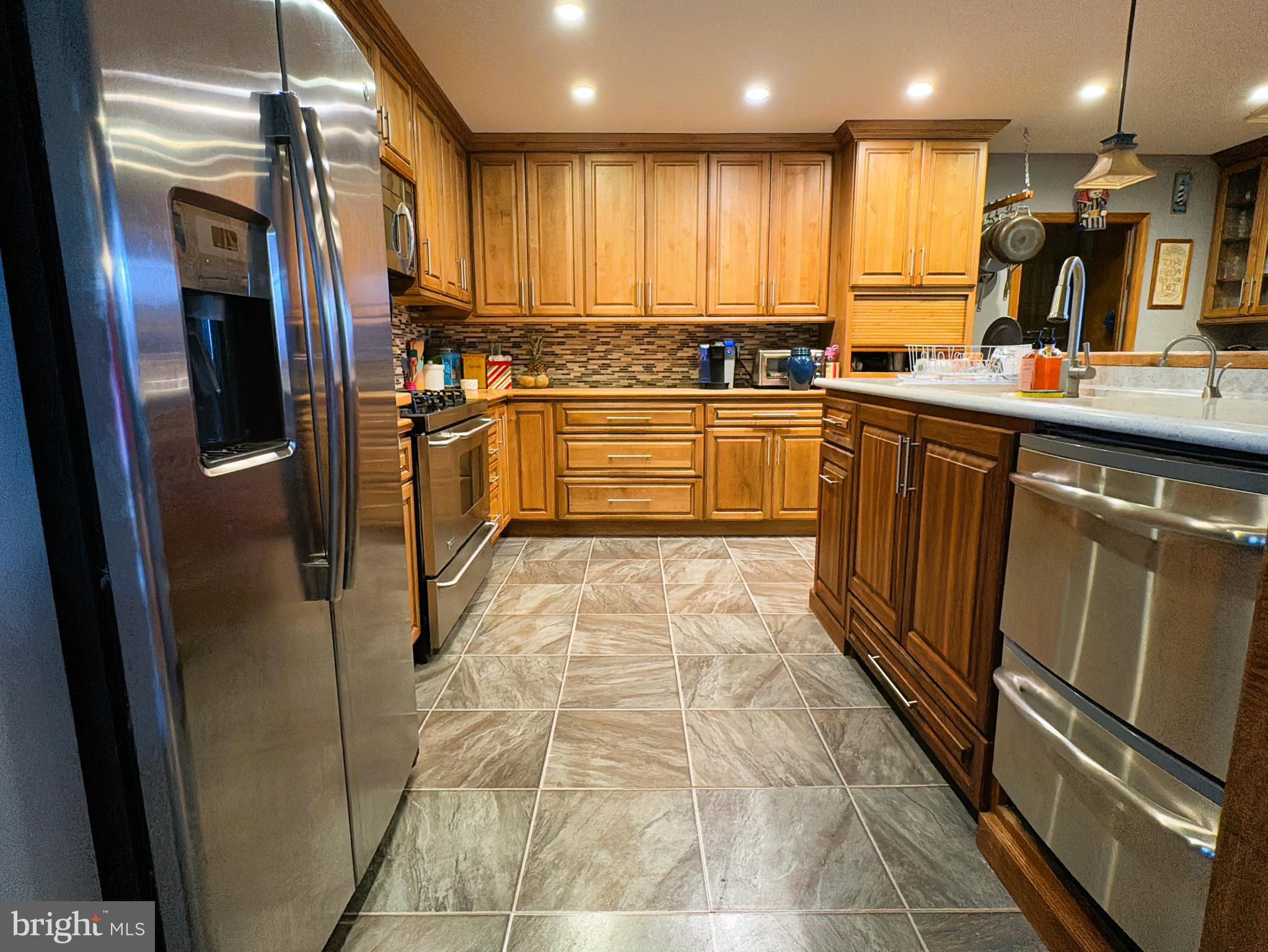 a kitchen with stainless steel appliances granite countertop a refrigerator and a sink