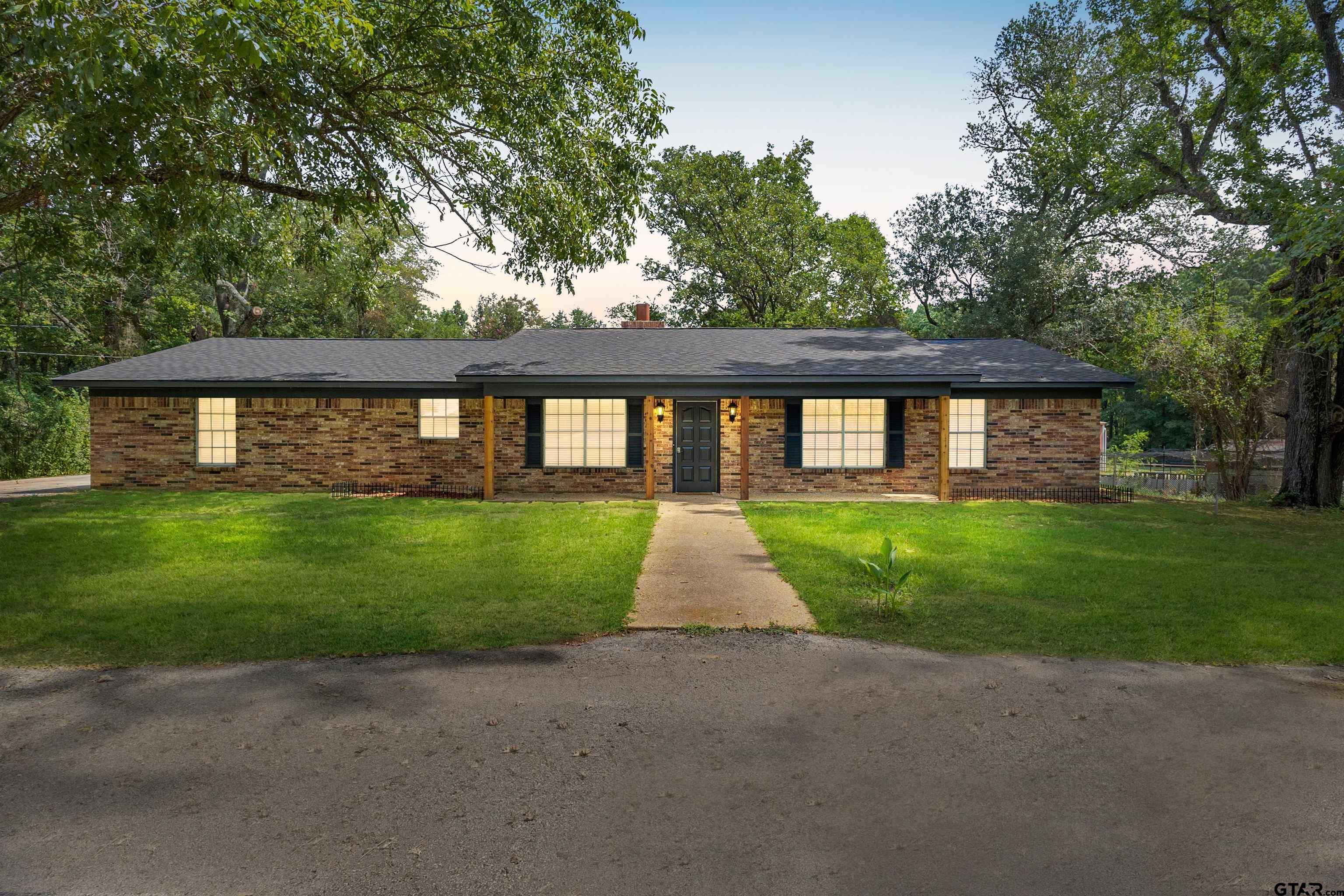 a front view of a house with a yard and garden