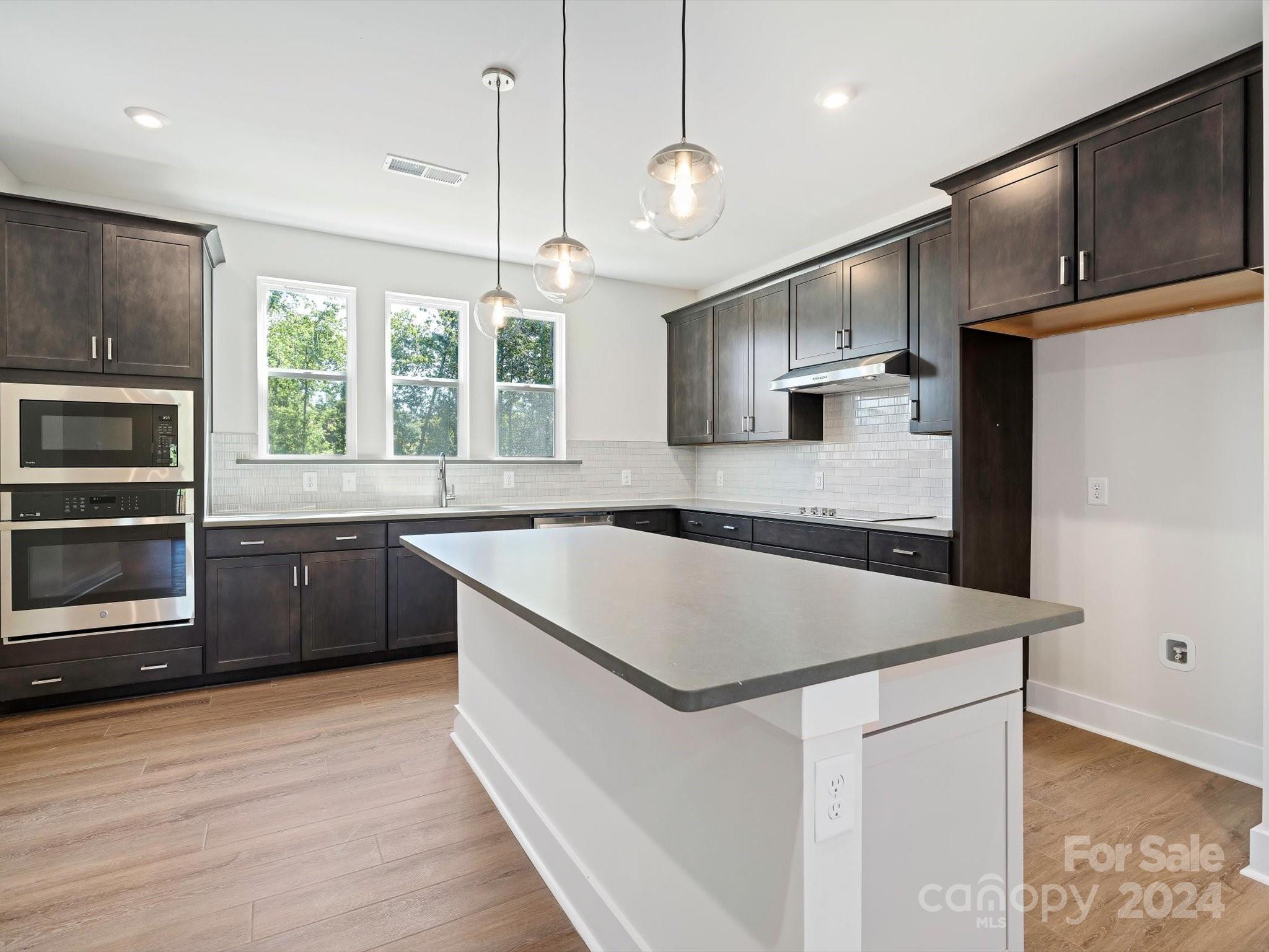 a kitchen with a stove a sink and a refrigerator