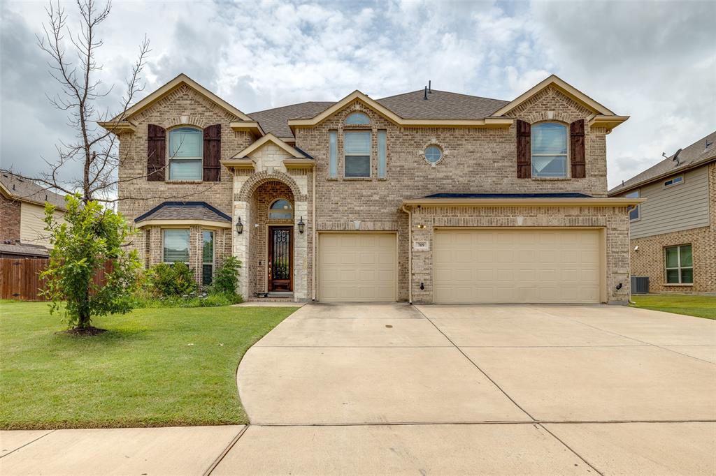 View of front of home with a garage and a front yard