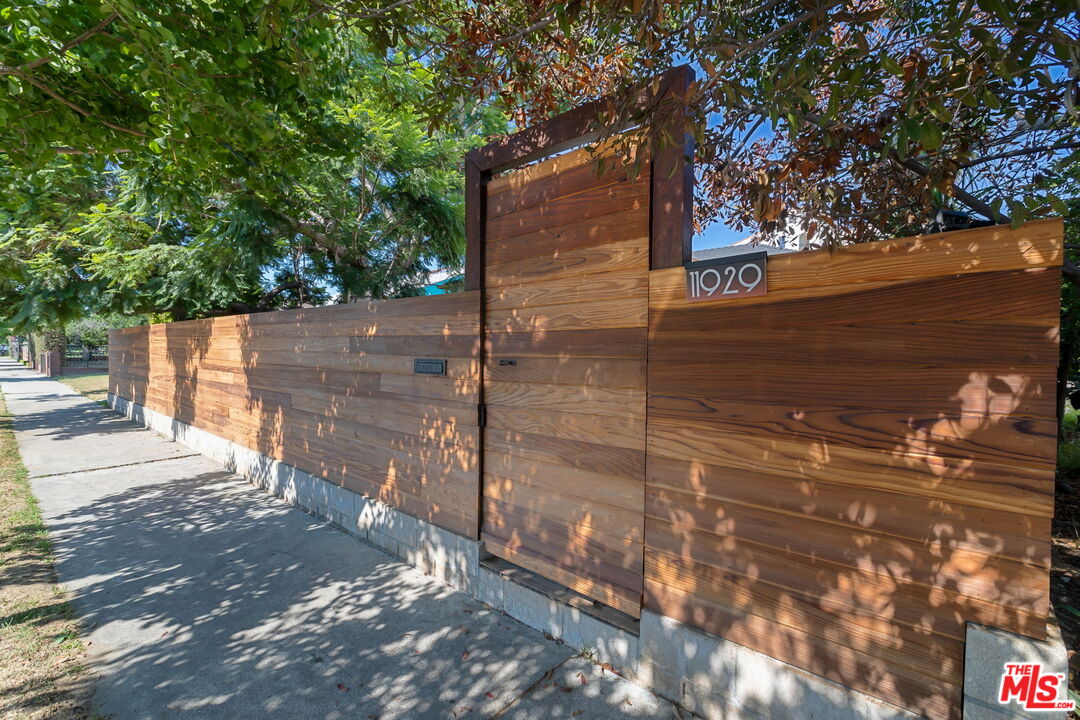 a view of a street with wooden fence