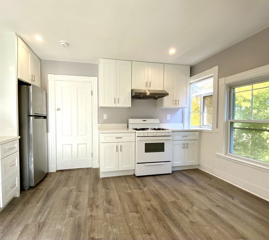 a kitchen with white cabinets and white appliances