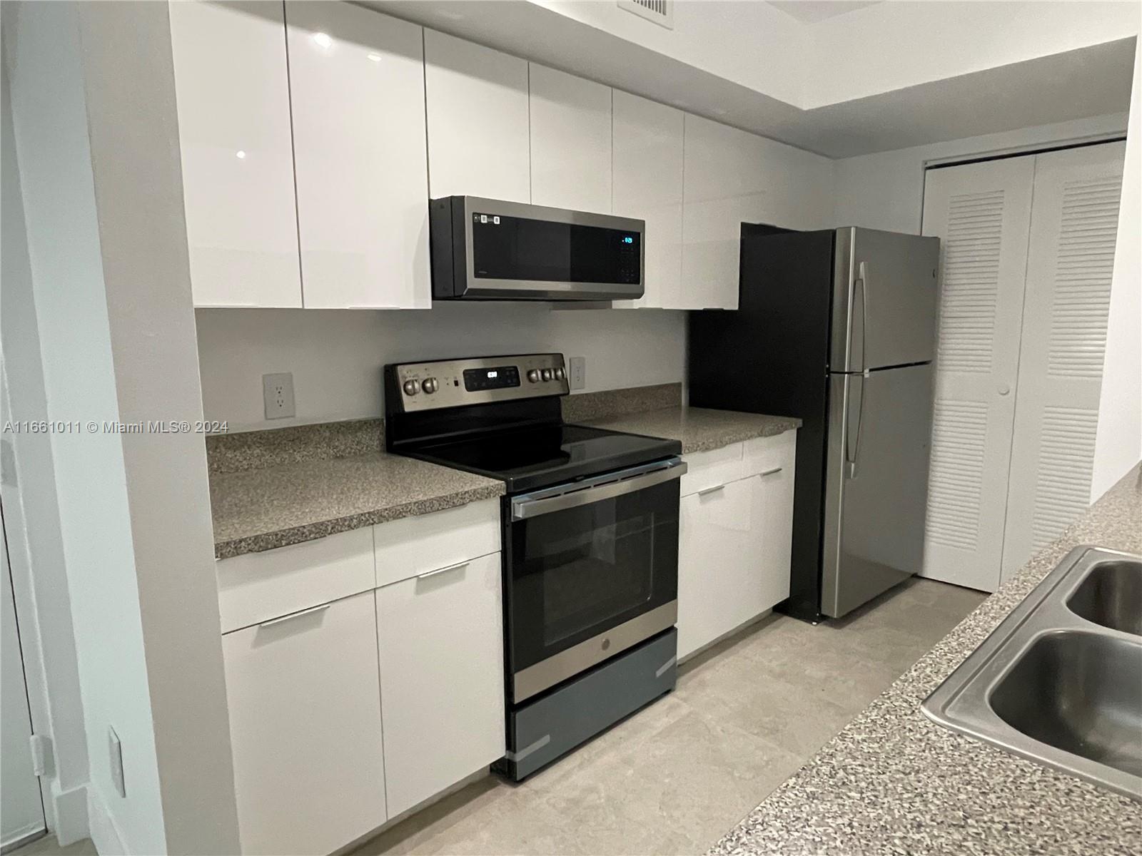 a kitchen with a sink appliances and cabinets