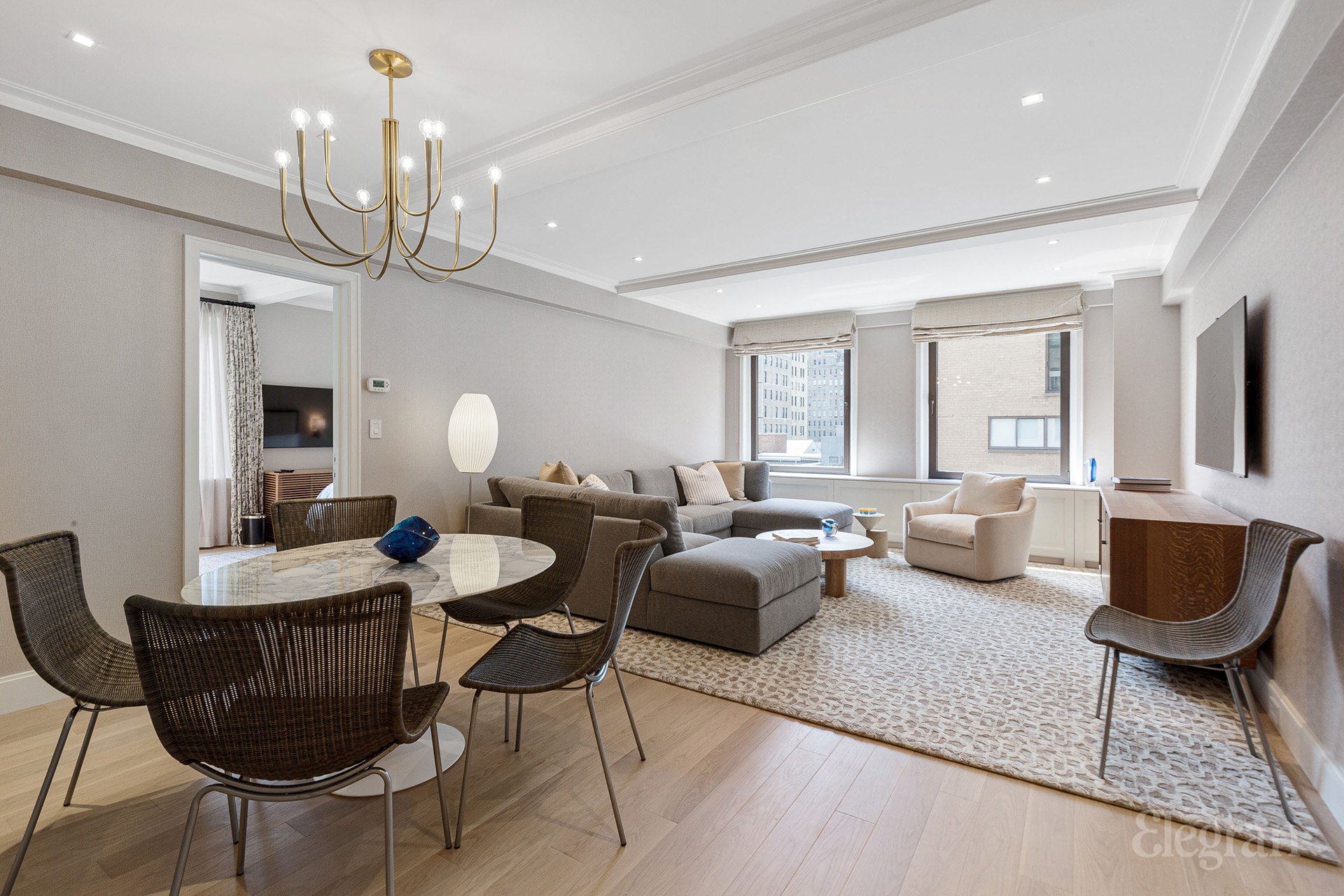 a living room with furniture a chandelier and a rug