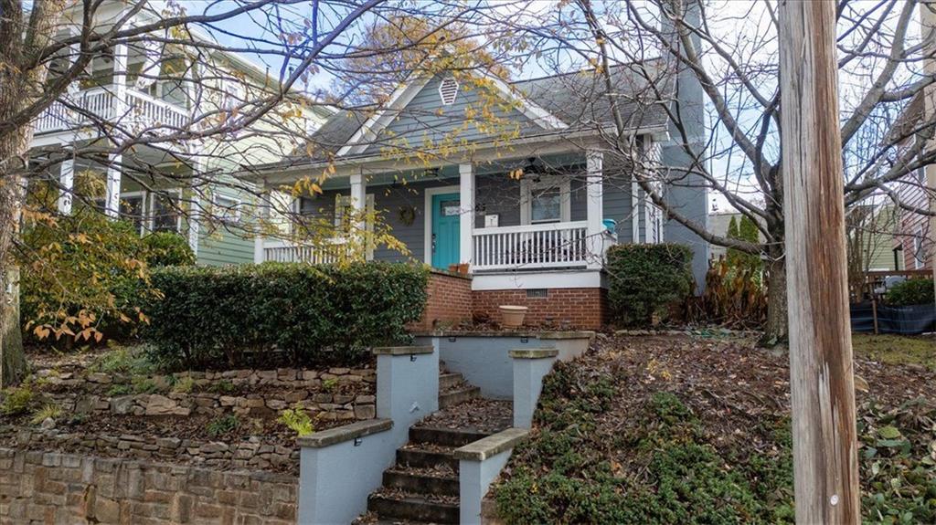 a view of a house with a yard and potted plants