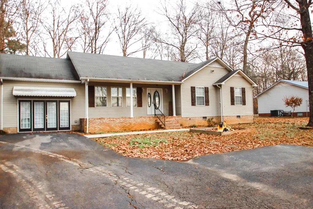 a front view of a house with a dirt road and yard