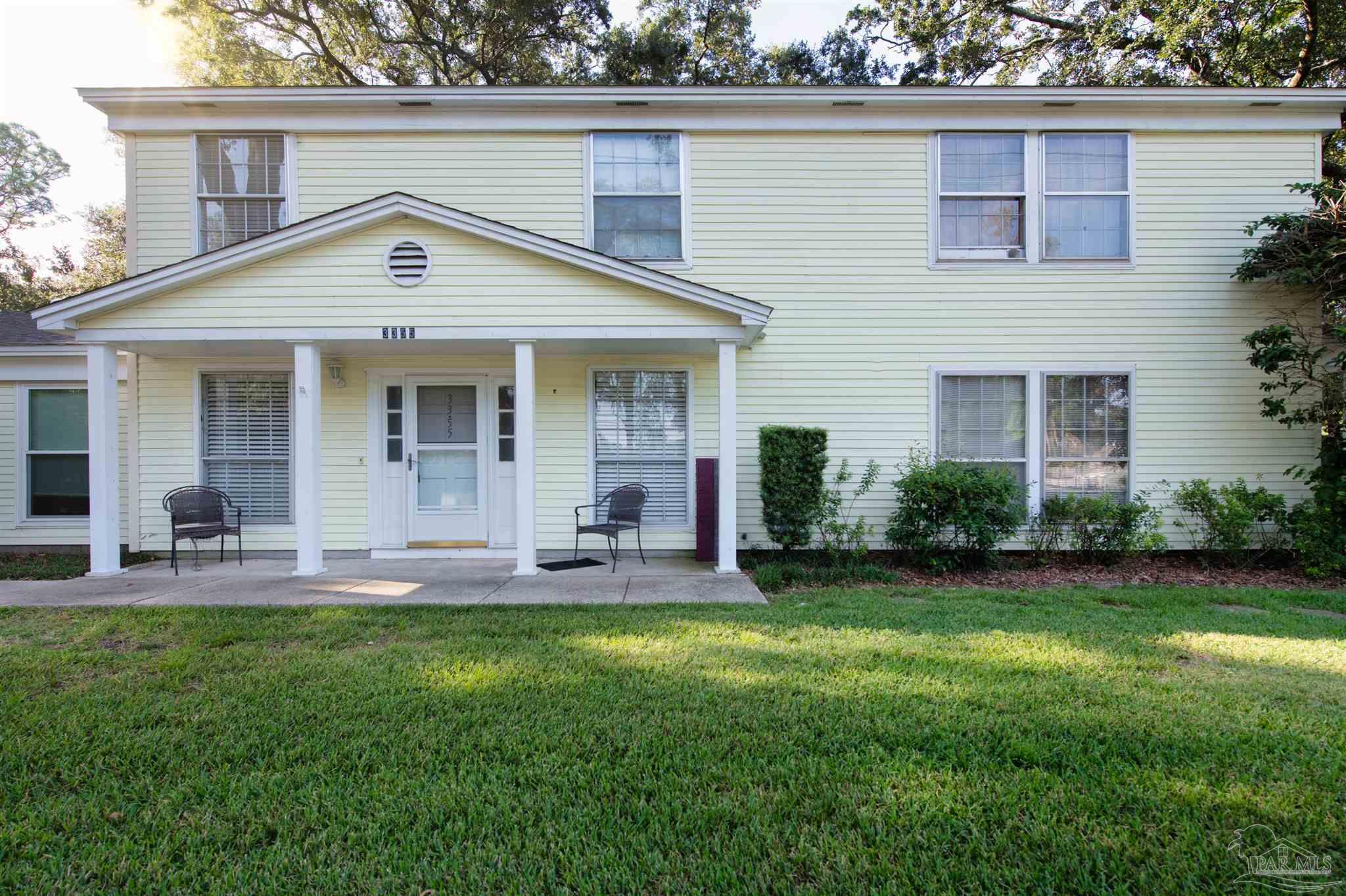 a front view of house with a garden and patio