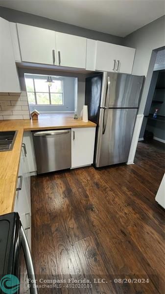 a kitchen with stainless steel appliances a refrigerator a sink and a stove