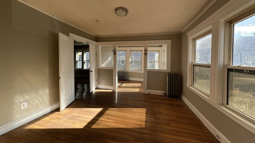 a view of a hallway with wooden floor and a living room