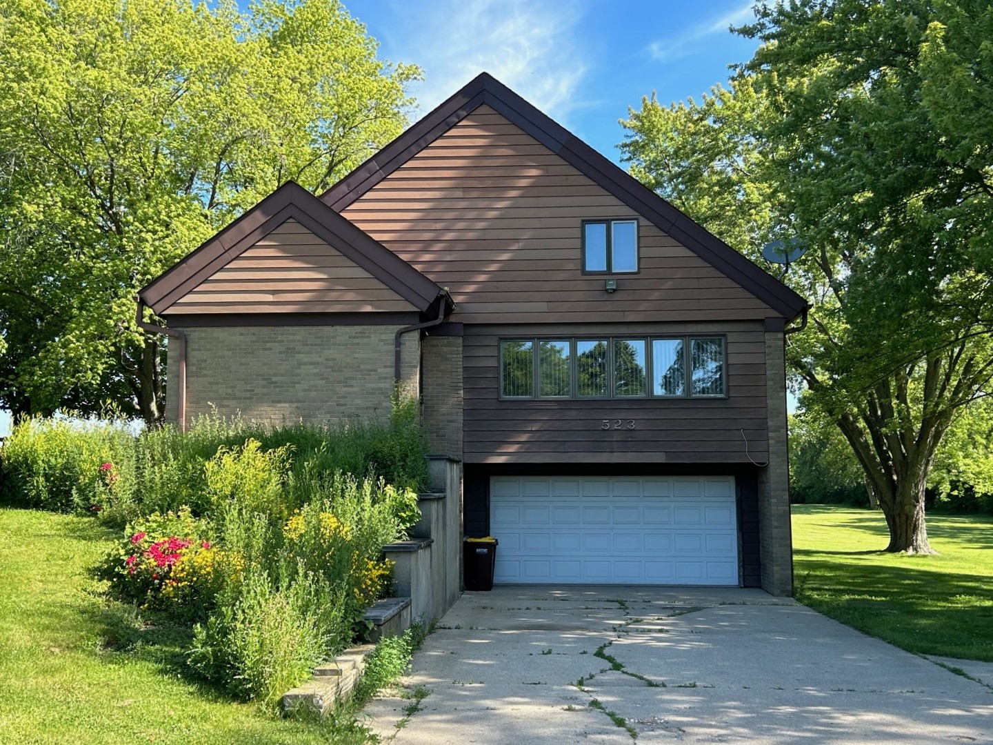 a front view of house with a garden