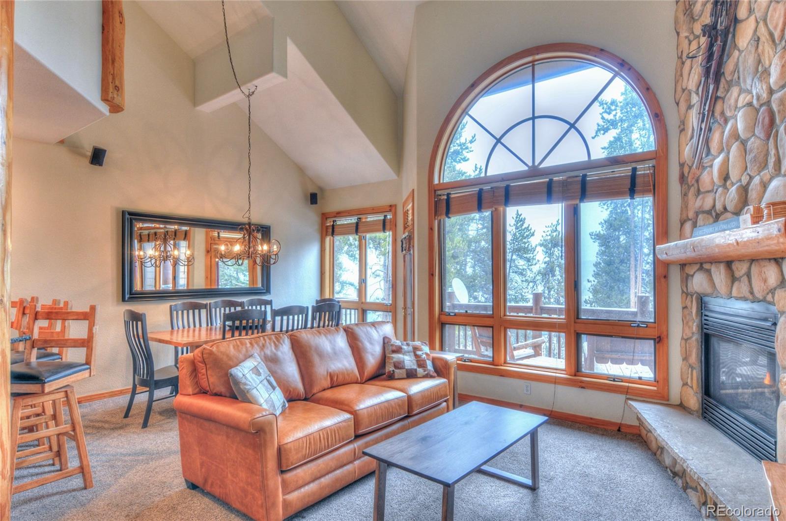 a living room with furniture a fireplace and a large window