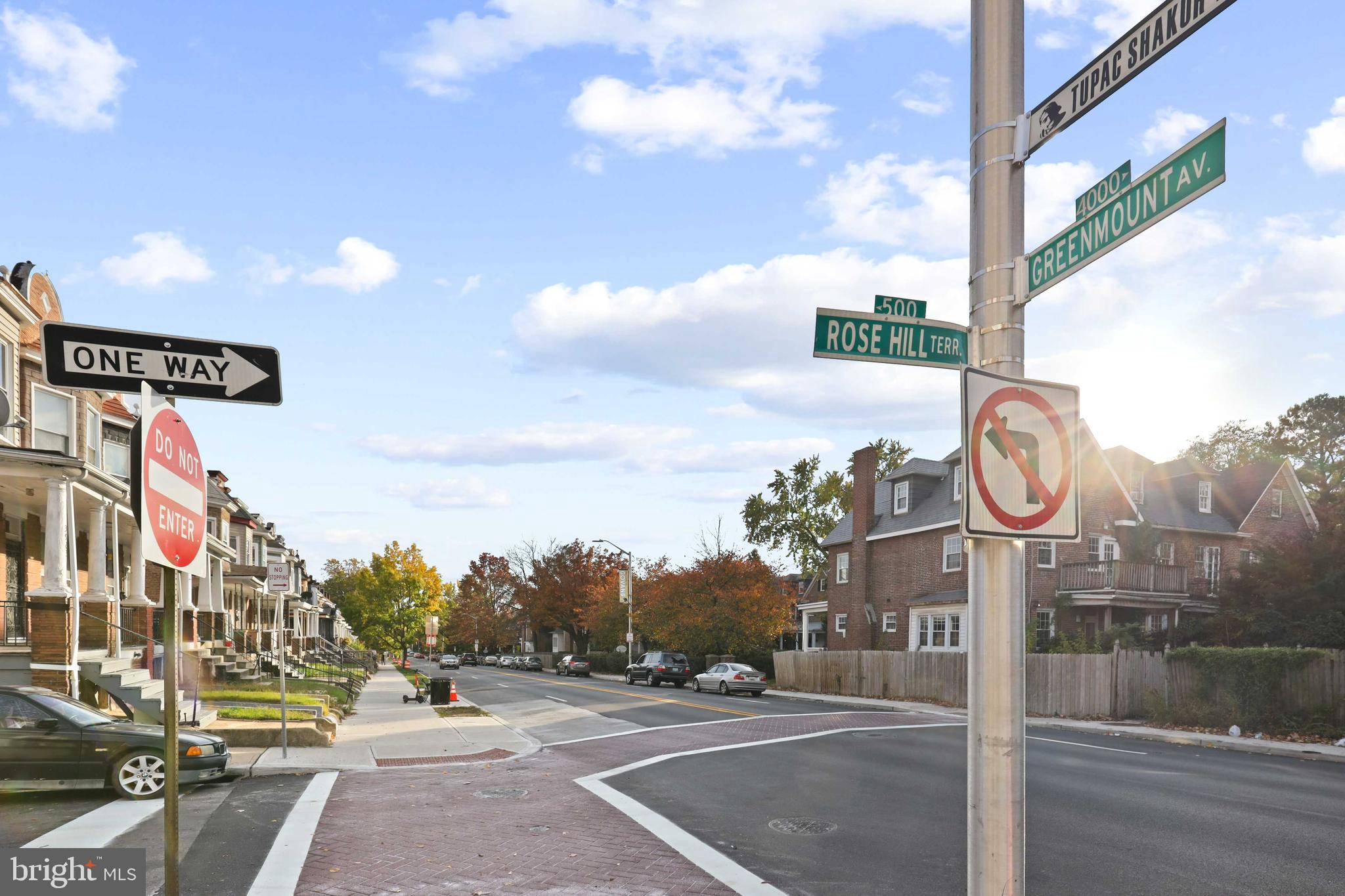 a street sign on a sidewalk next to a road