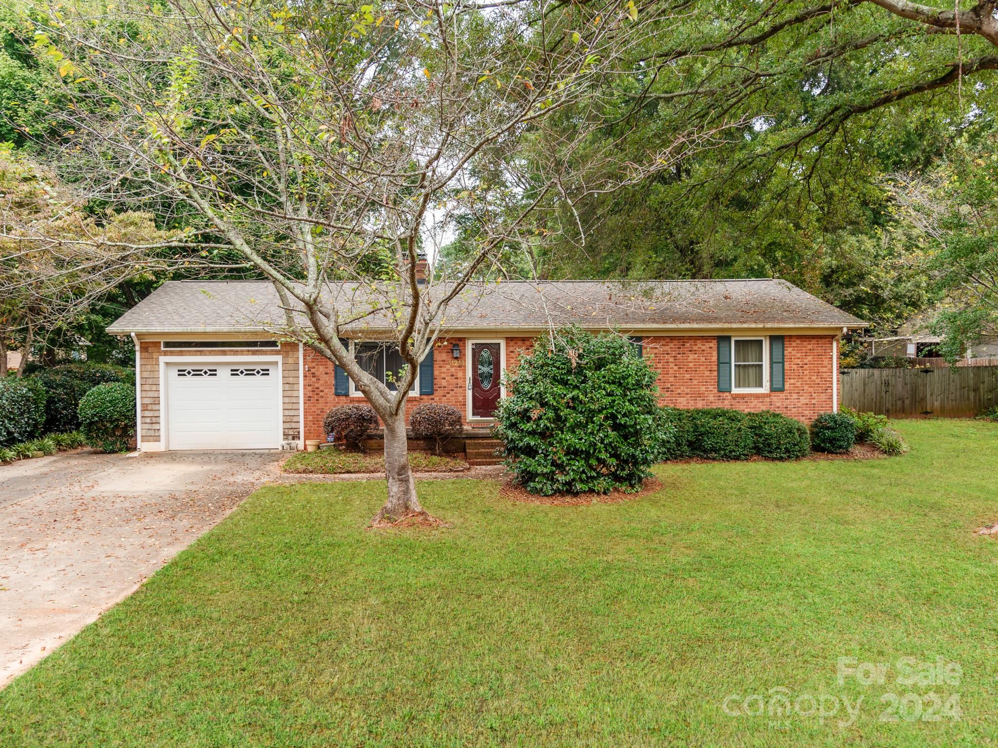 a front view of a house with a yard and trees