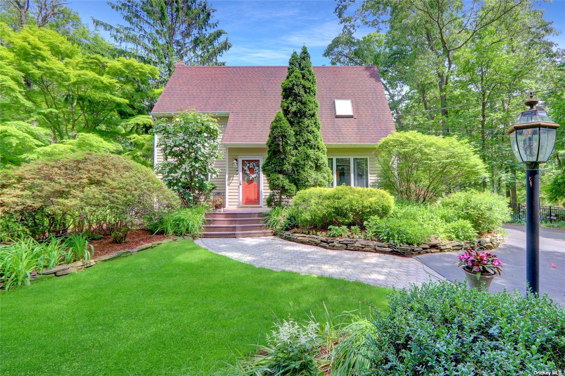 a front view of a house with a yard and a tree