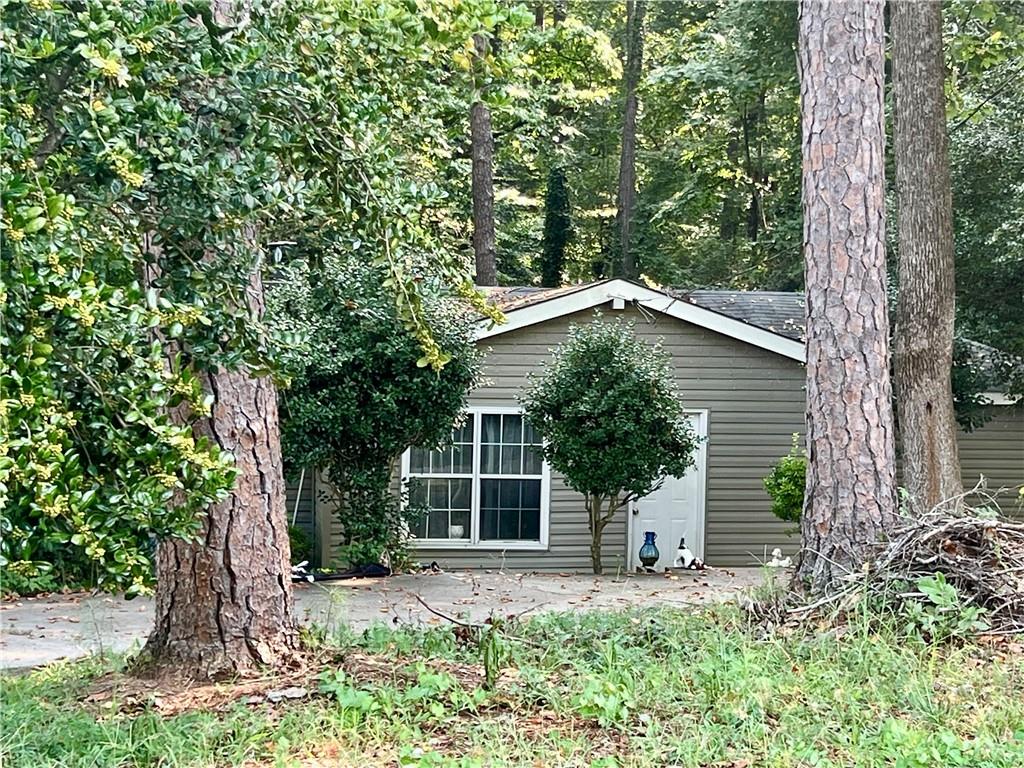 front view of a house with a yard and an trees