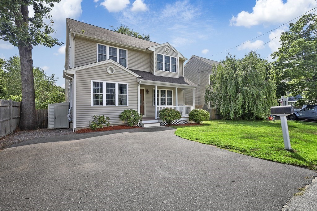 a front view of a house with a yard and trees