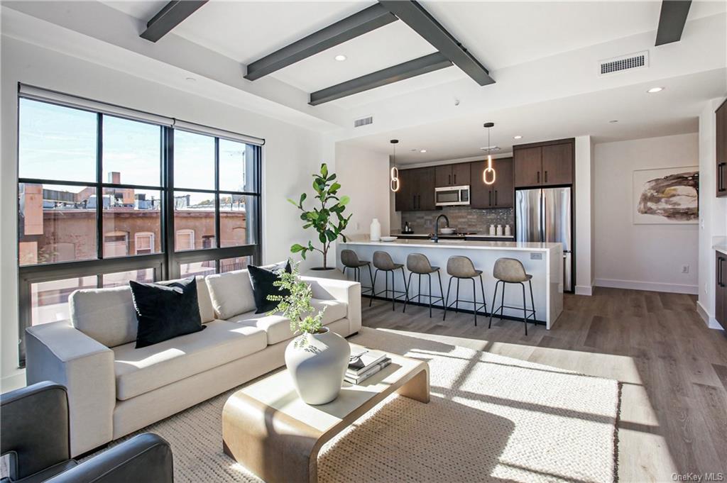 a living room with furniture fireplace and a large window