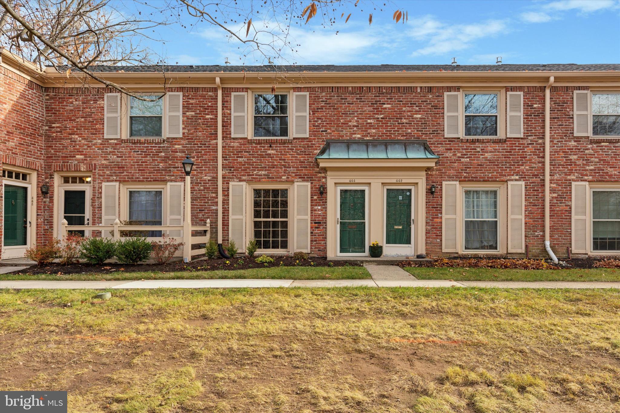 front view of a brick house with a yard