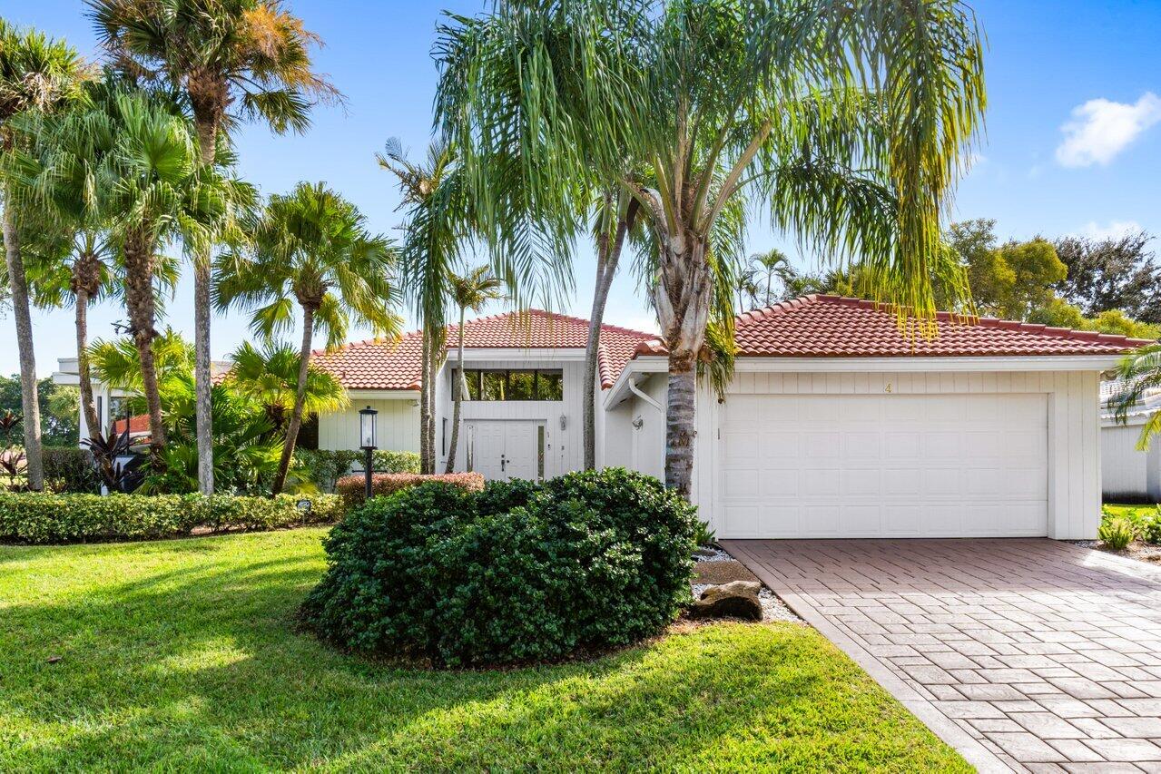 a view of a house with a yard and palm trees