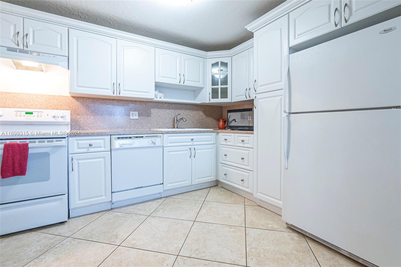 a kitchen with white cabinets and white appliances