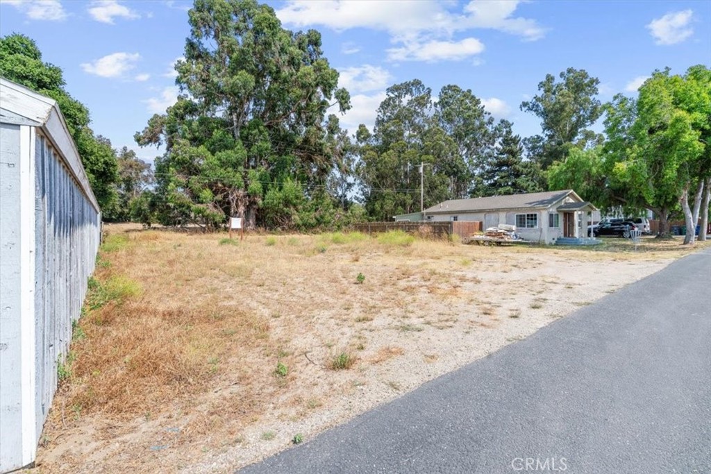 a view of house with yard and trees in the background