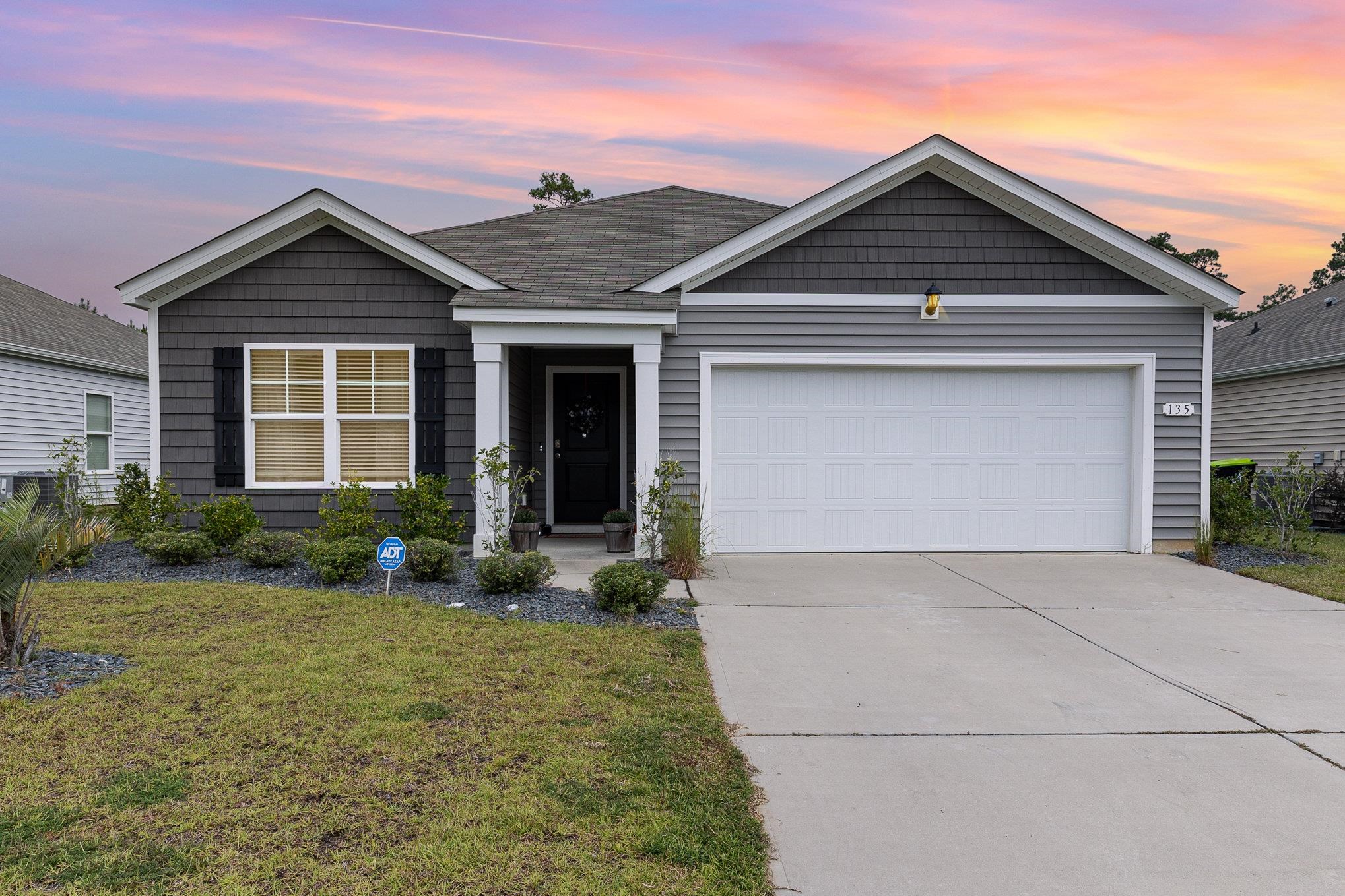 View of front facade with a lawn and a garage