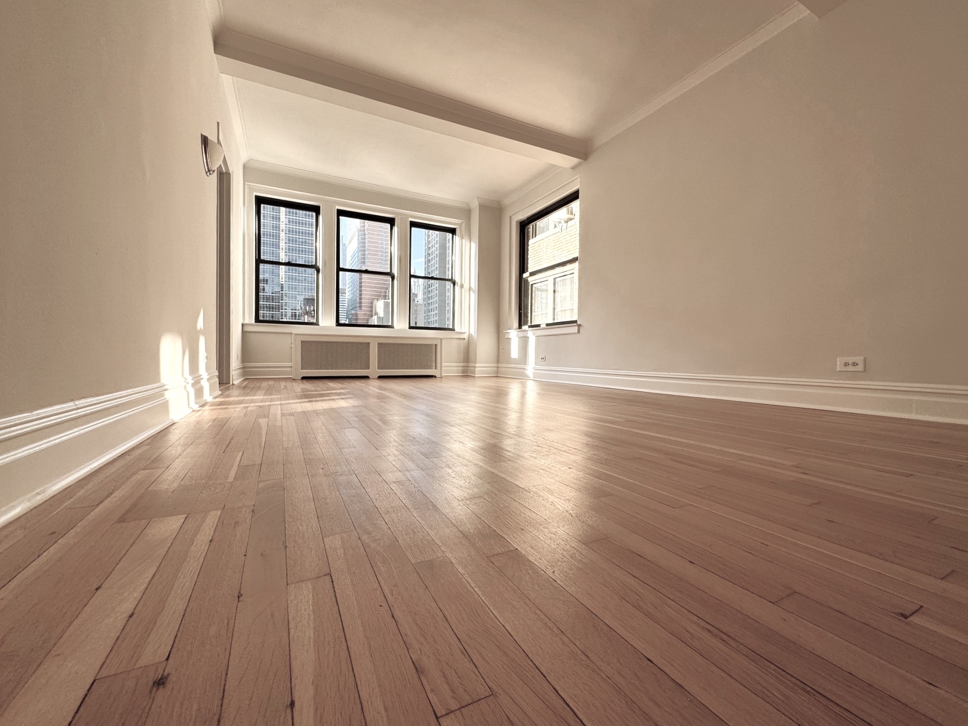 wooden floor in an empty room with a window