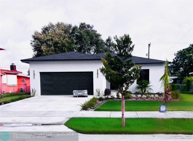 a front view of a house with a garden and plants