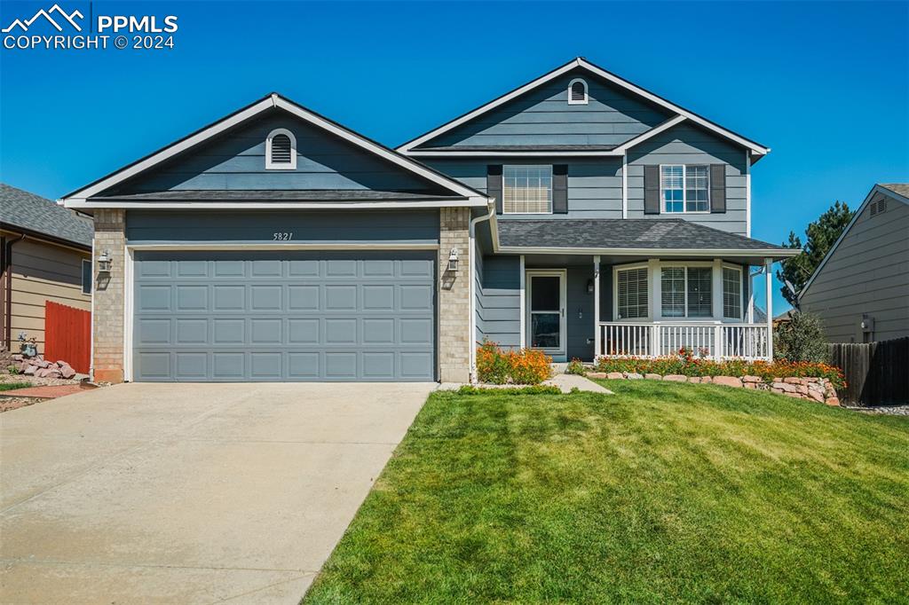 Craftsman-style home with a front yard, covered porch, and a garage