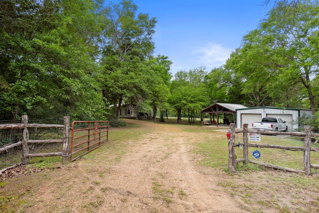 WELCOME!! This is the perfect property located centrally between Houston, Dallas, Austin and Waco! 32.45 fenced acres of gorgeous mature trees with 4 bedrooms/2 full baths. 2 - 2 car garages with entertainment covered porch.