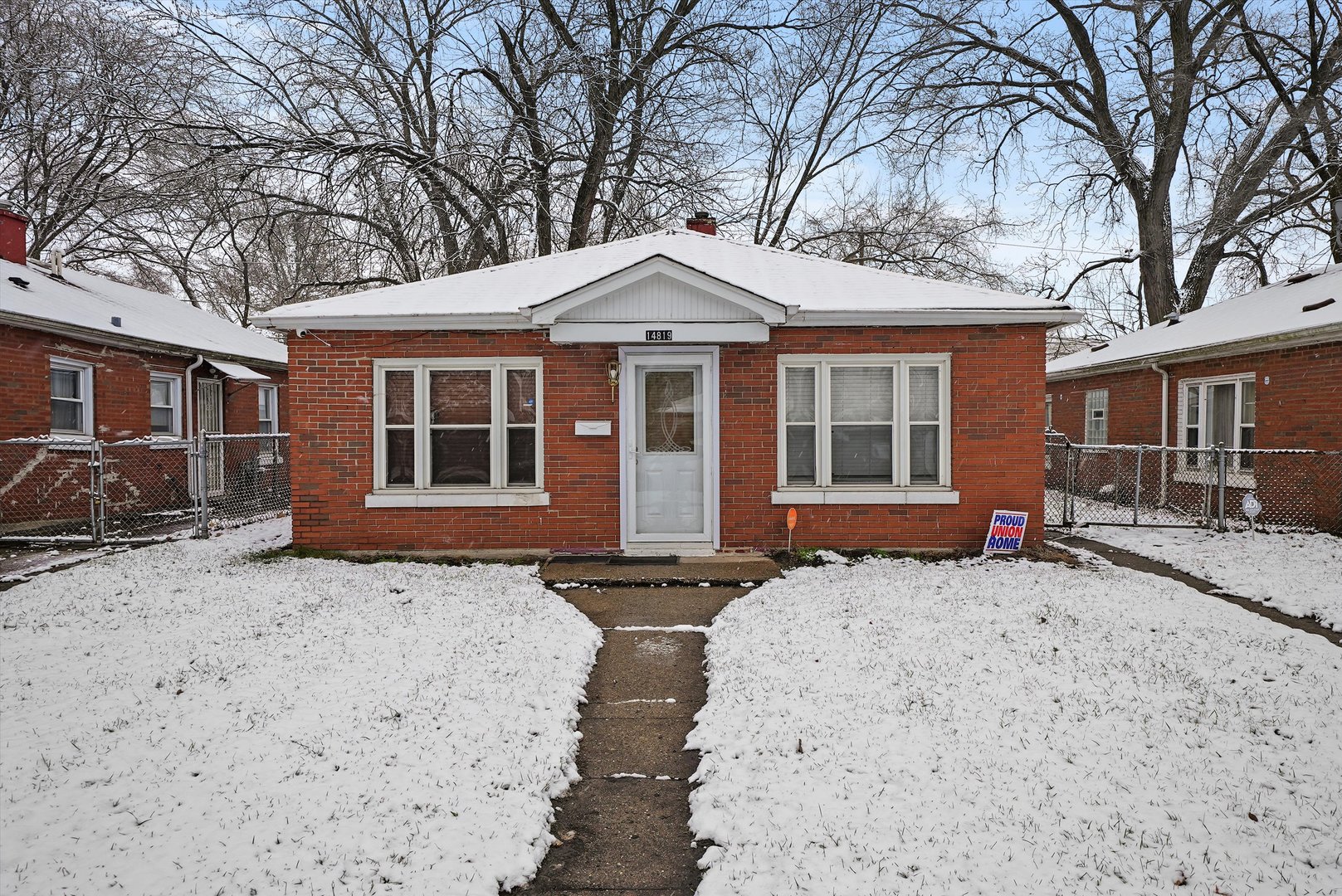 a front view of a house with a yard covered in snow