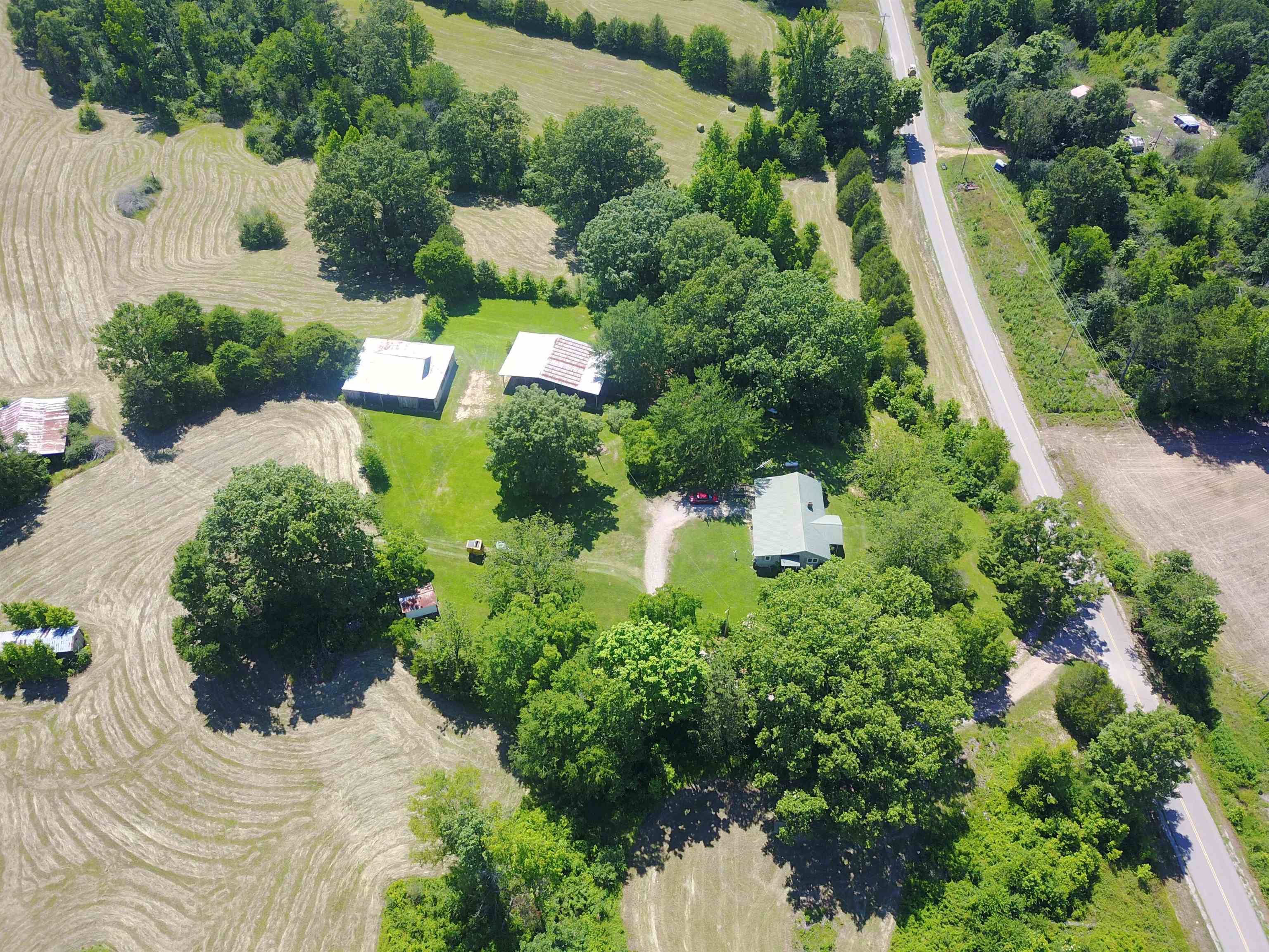 an aerial view of a house with a yard and large trees