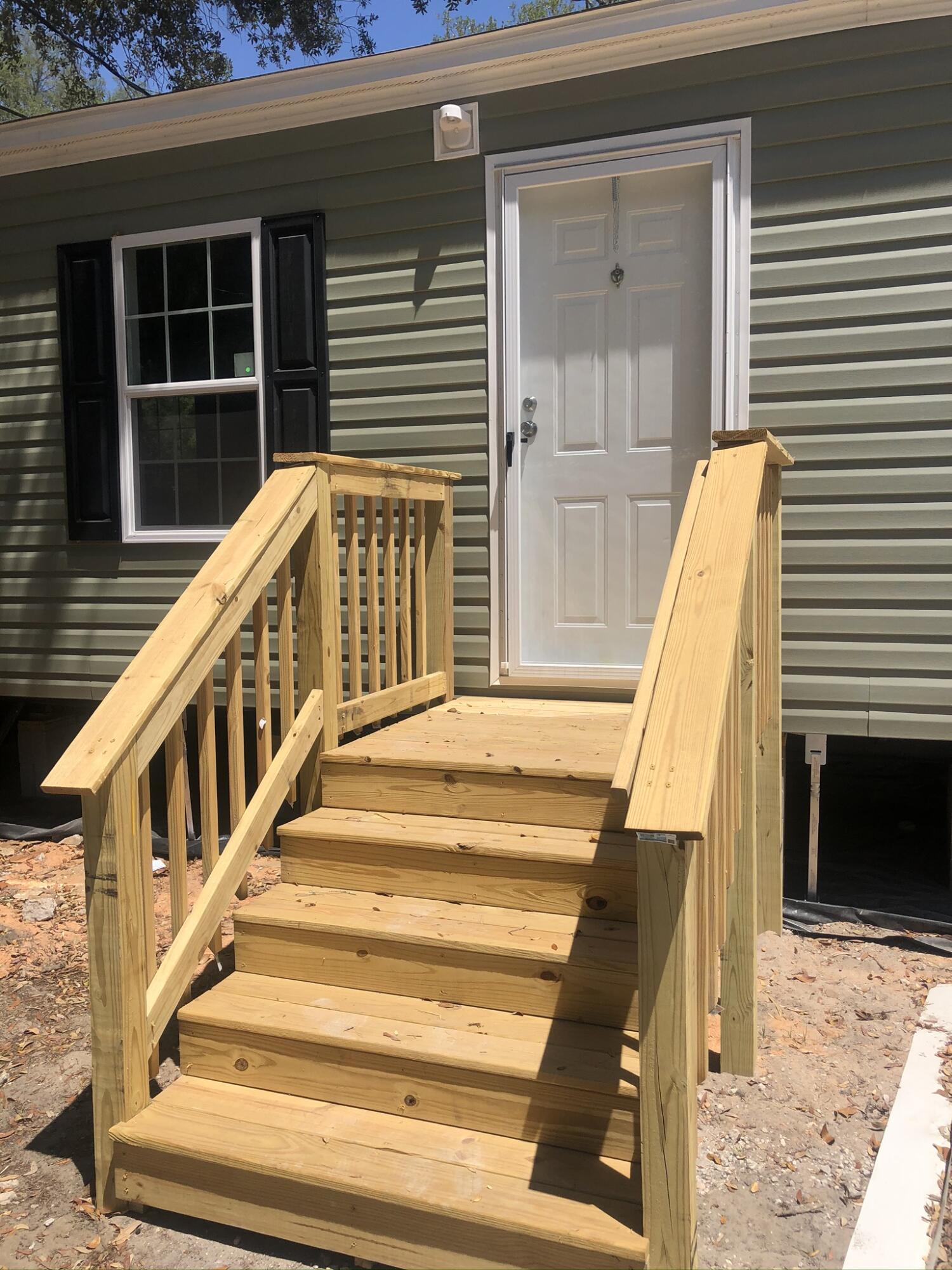 a view of staircase with white door and wooden floor