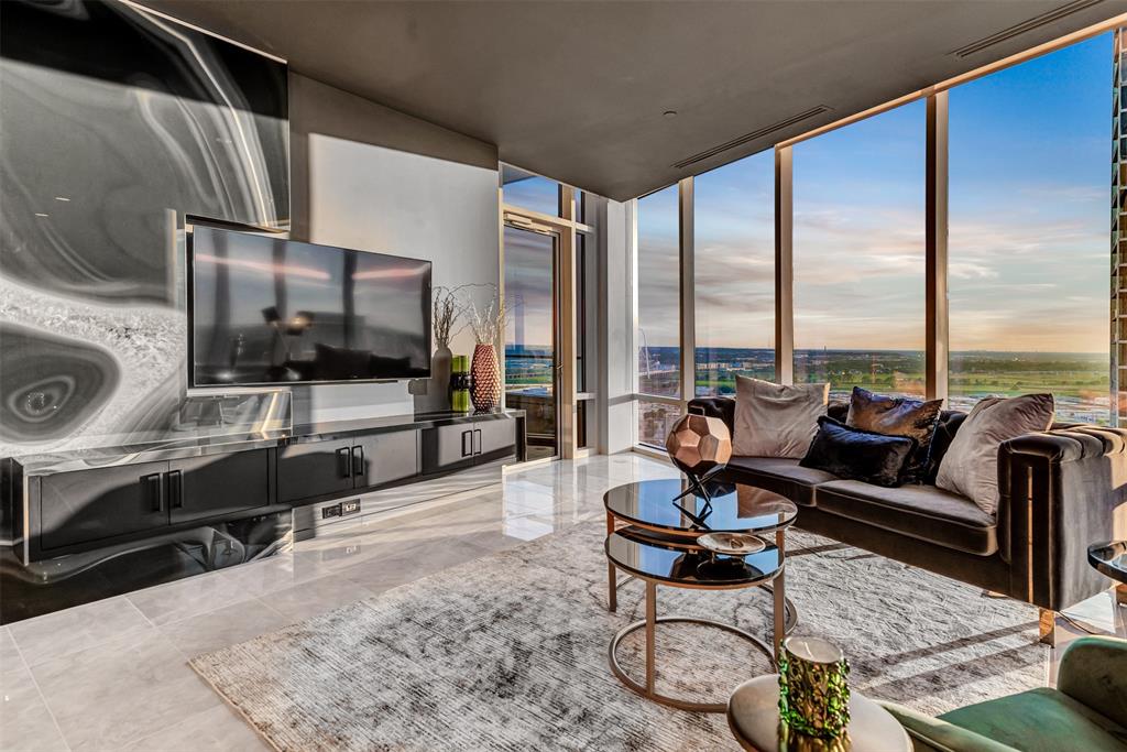 a living room with furniture a flat screen tv and a floor to ceiling window