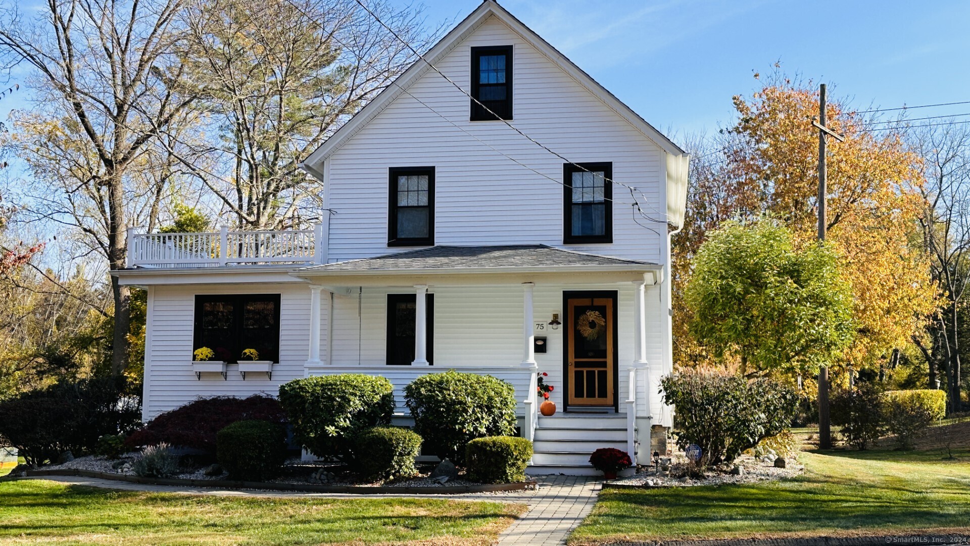 a front view of a house with a yard garage and chairs