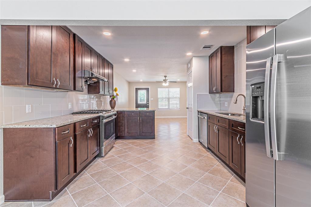 a large kitchen with stainless steel appliances and large cabinets