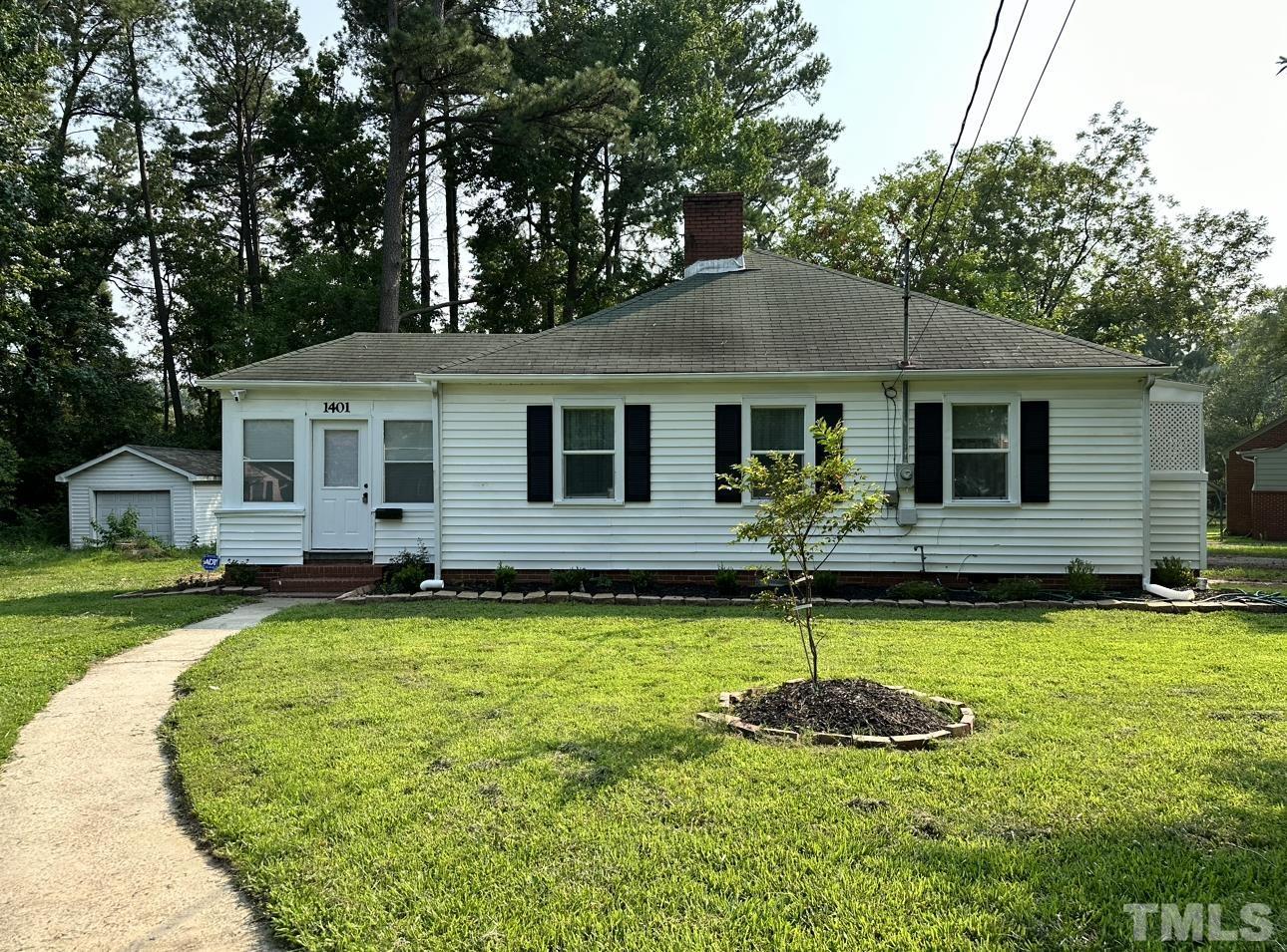 a front view of a house with swimming pool and yard