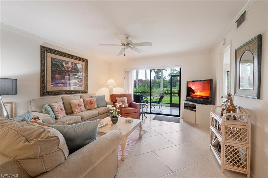 Tiled living room featuring ornamental molding and ceiling fan